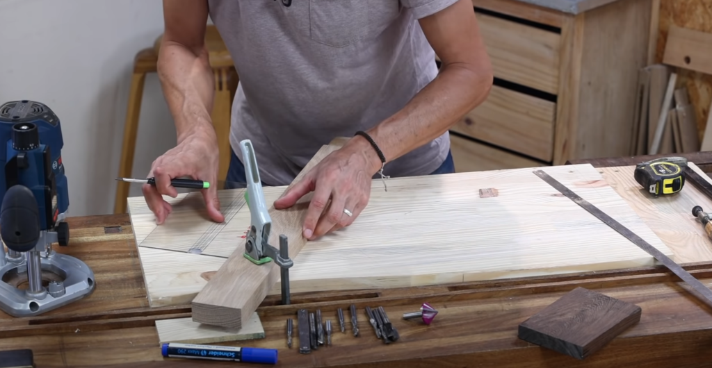 Mise en appui et fixation d’un tasseau de guidage contre le gabarit pour guider la défonceuse