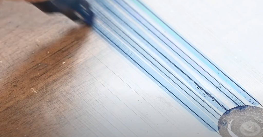 Marquage des traits du gabarit en plexiglas avec un feutre pour améliorer la lisibilité